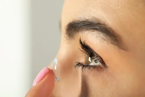 Woman inserting prescription contact lens for clear vision